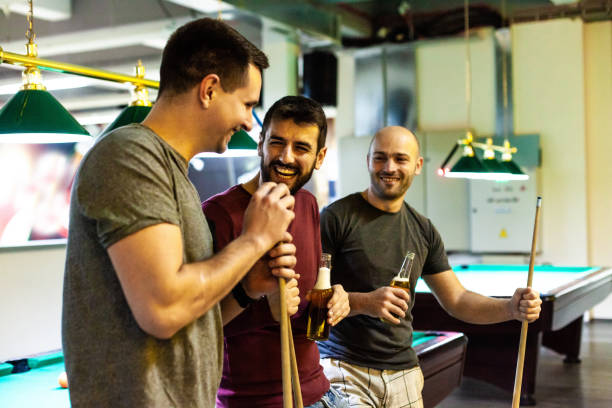 istock Men laughing and having beer in pool hall 1080423962