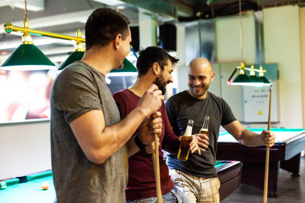 istock Men laughing and having beer in pool hall 1080423970