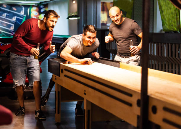 istock Men having fun playing shuffleboard at the bar 1080424584