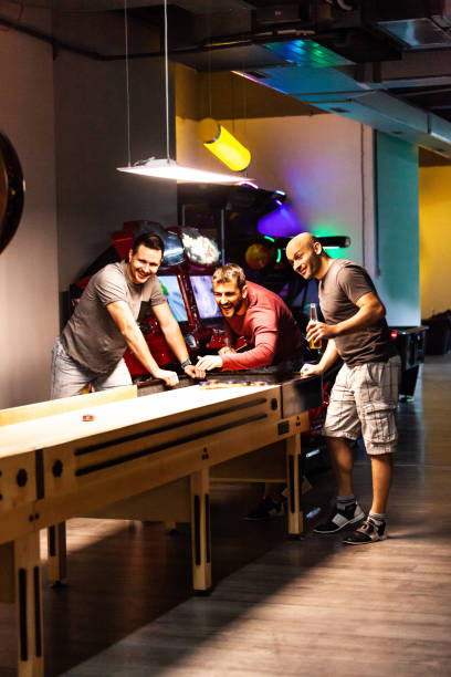 istock Men having fun playing shuffleboard at the bar 1080424600