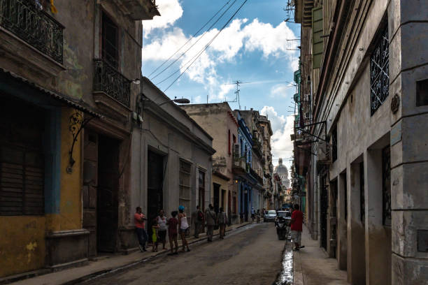 Havana, Cuba. 21st November 2018. Local people walking and on mopeds, on the residential streets in old town Havana.