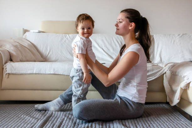 istock Cute small boy with Down syndrome playing with mother in home 1080426794
