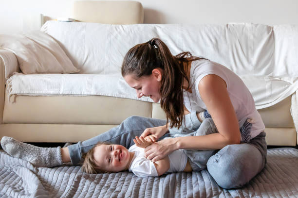Cute small boy with Down syndrome playing with mother in home Cute small boy with Down syndrome playing with mother in home living room down syndrome photos stock pictures, royalty-free photos & images