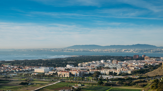 High perspective view of Greater Lisbon from Miradouro Aldeia dos Capuchos in Costa de Caparica, Almada. Palacio Pena in Sintra is visible in far right background