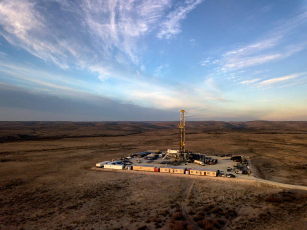 Fracking Drilling Rig at Dusk or Dawn Desolate drilling rig in West Texas at the Golden Hour wellhead stock pictures, royalty-free photos & images