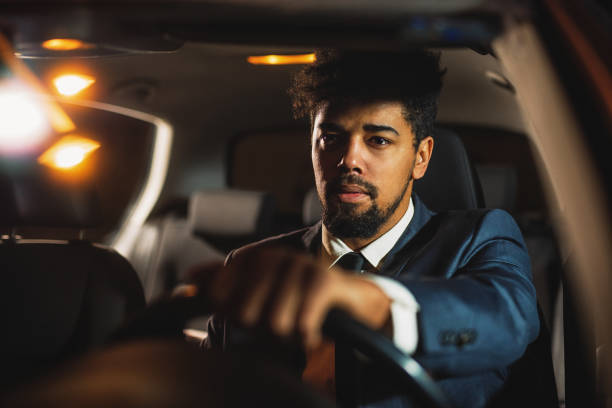 istock Handsome man in a suit driving a car 1080458822