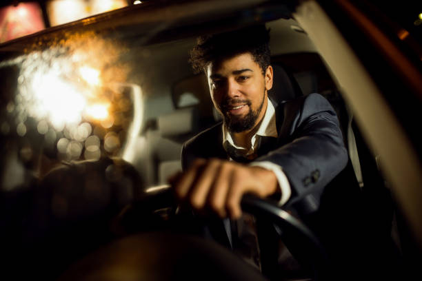 istock Handsome man in a suit driving a car with the smile on 1080461450