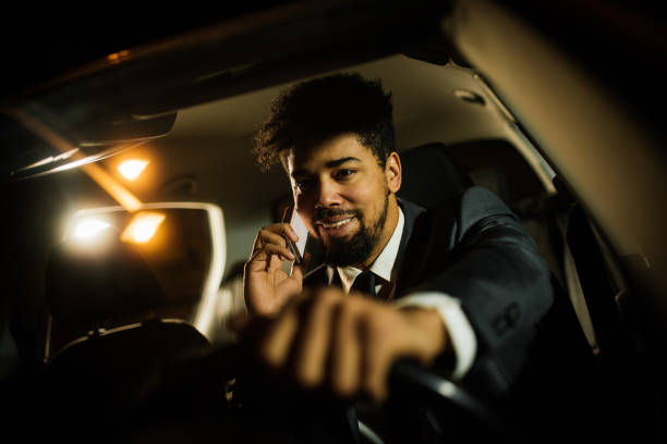 istock Handsome man smiling and talking on the phone in the car 1080462822