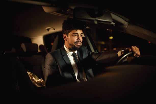 istock Handsome man in a suit driving a car with the smile on 1080463612