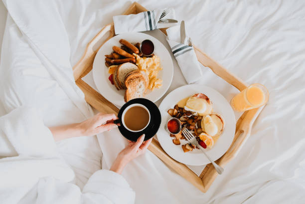 Breakfast in bed Woman in bed enjoying breakfast. luxury hotel photos stock pictures, royalty-free photos & images