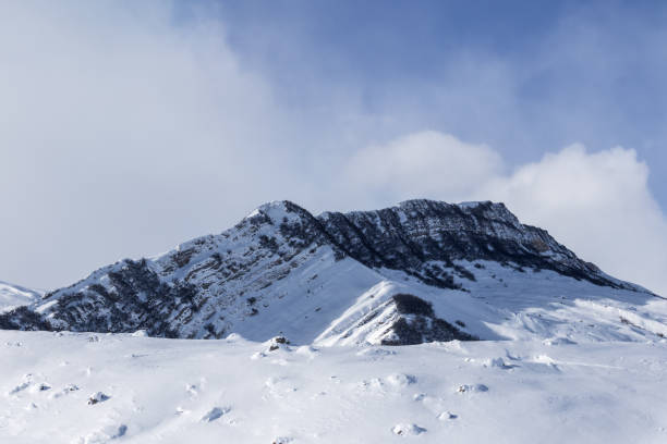 istock Snowy mount range with forest and sunlight slope 1080495674