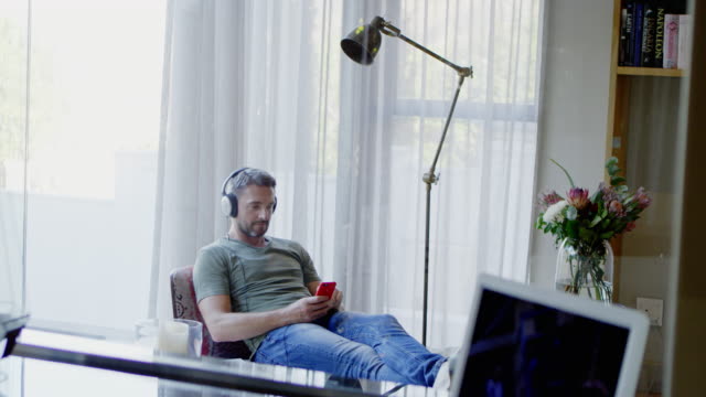 Man relaxing, listening to music with headphones and mp3 player