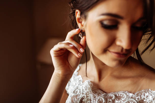 istock Beautiful elegant bride puts on earrings 1080518686