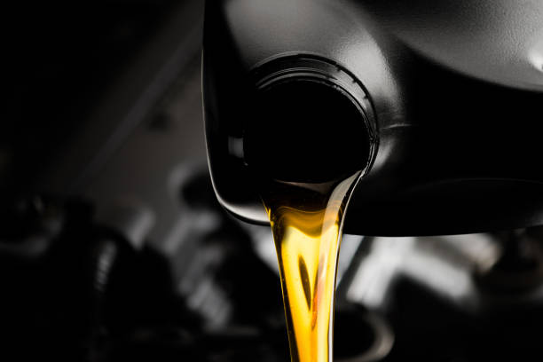 verter el aceite lubricante de automóvil de botella negra sobre fondo de motor, taller de reparación de automóviles de servicio aceite cambio - motor oil bottle fotografías e imágenes de stock
