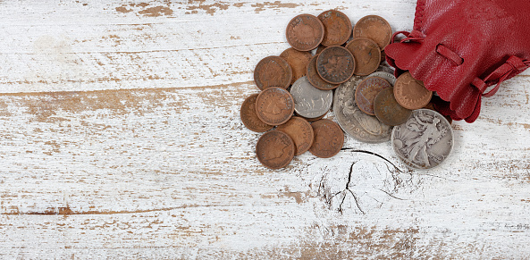 Bag of vintage United States coins on white rustic wood