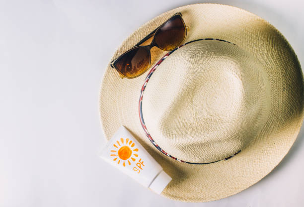 accessori da spiaggia. cappello estivo, occhiali da sole e lozione abbronzante - sun protection foto e immagini stock