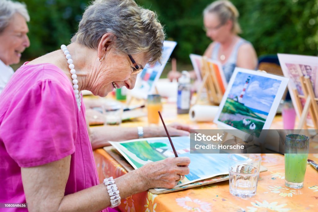 Mulher sênior, sorrindo enquanto desenho com o grupo. - Foto de stock de Terceira idade royalty-free