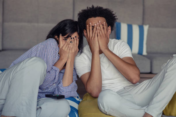 istock Young couple at home watching a movie with popcorn 1080553616