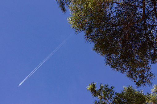 jet with contrails on blue sky in south germany countryside