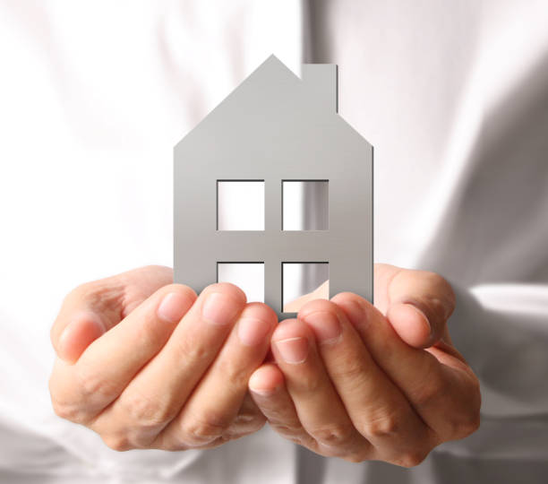 istock Mortgage concept by house from  hand 1080558872