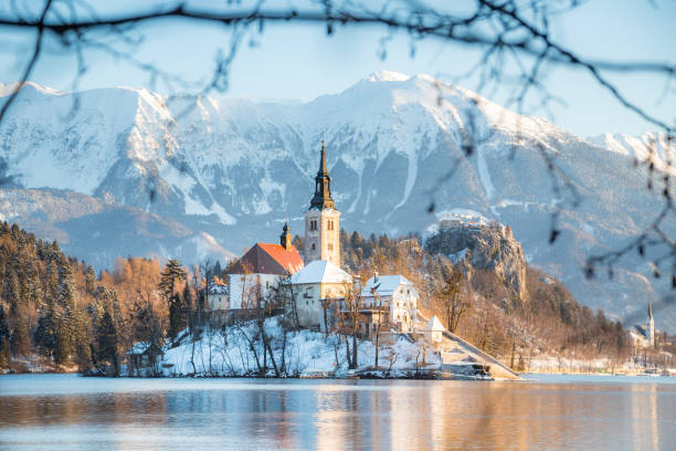 bleder see mit bleder insel und schloss bei sonnenaufgang im winter, slowenien - castle slovenia winter snow stock-fotos und bilder