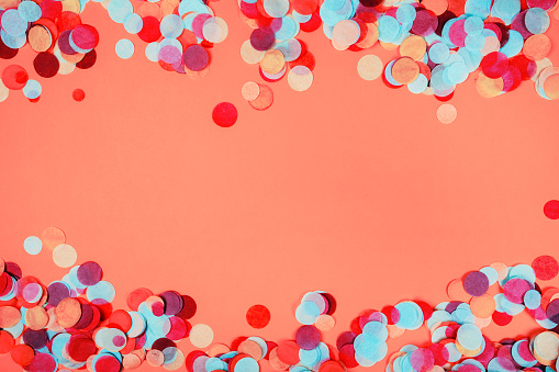Multicolored festive confetti as a frame Flat lay style. Ispired by color of the year 2019 - Living Coral.