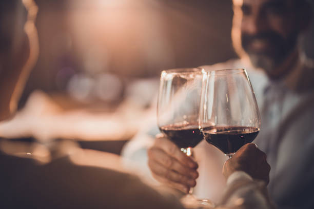 Close up of toasting with wine in a restaurant! Close up of a couple toasting with red wine in a restaurant. couple drinking stock pictures, royalty-free photos & images