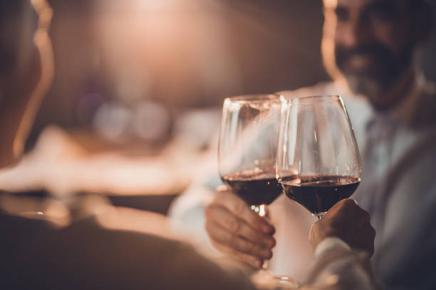 close up of toasting with wine in a restaurant! - dating restaurant dinner couple imagens e fotografias de stock