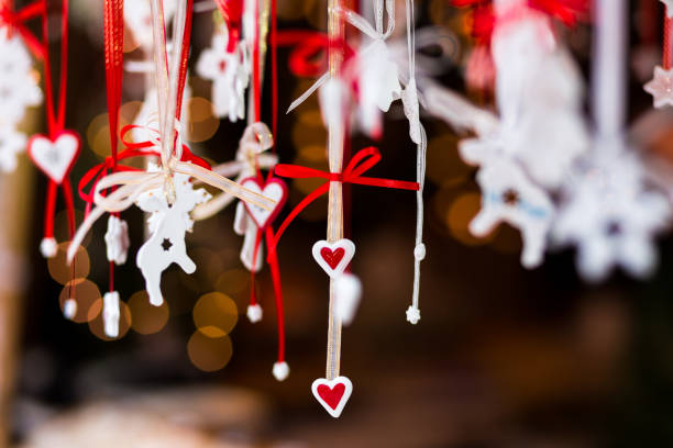 decoraciones artesanales en una fila en el mercado de navidad - heart shape christmas defocused multi colored fotografías e imágenes de stock