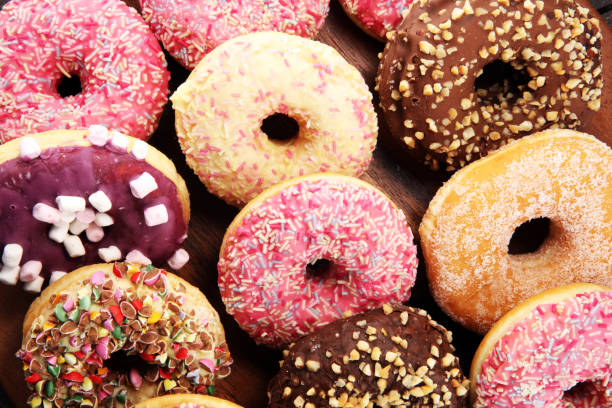 istock assorted donuts with chocolate frosted, pink glazed and sprinkles donuts 1080674266