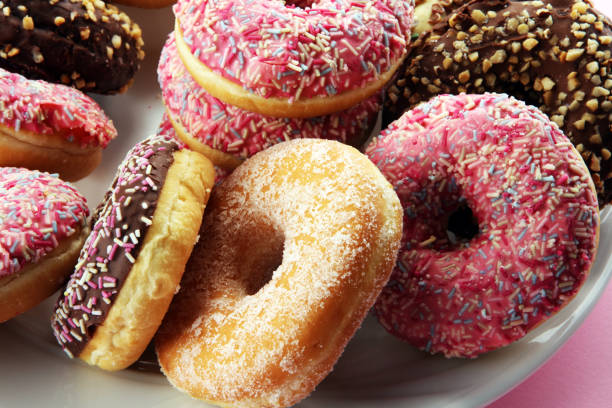 istock assorted donuts with chocolate frosted, pink glazed and sprinkles donuts 1080674680