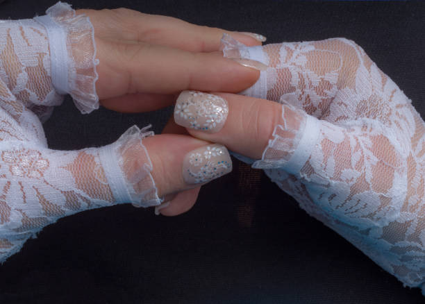 istock Nude colored nails with floral pattern stickers lace bridal gloves 1080675432