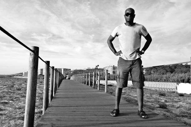 istock Man Posing On A Wooden Pier/Bridge. Black And White 1080693054