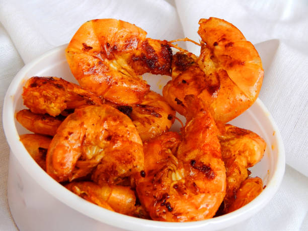 langostinos fritos en un plato blanco. ensalada de camarones - grilled shrimp flash fotografías e imágenes de stock