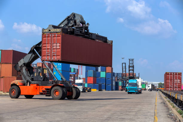 Forklift truck loading container to train in container warehouse for logistics shipping, import export or transportation.