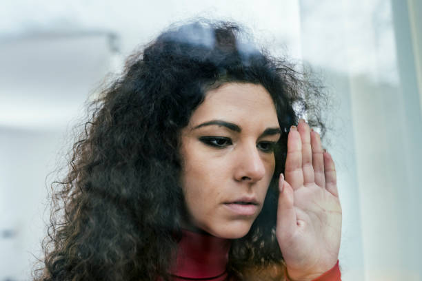istock Sad Woman Looking Through the Window 1080701478