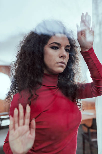 istock Sad Woman Looking Through the Window 1080702270