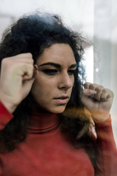 istock Sad Woman Looking Through the Window 1080702534