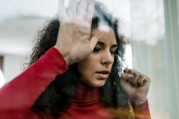 istock Sad Woman Looking Through the Window 1080702742