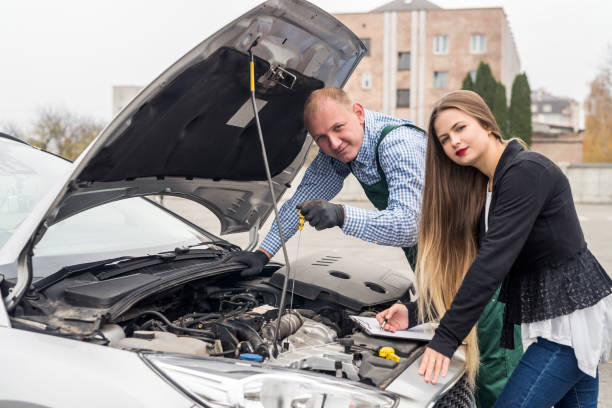 istock Worker checking lubricant level and woman writing on clipboard 1080703232