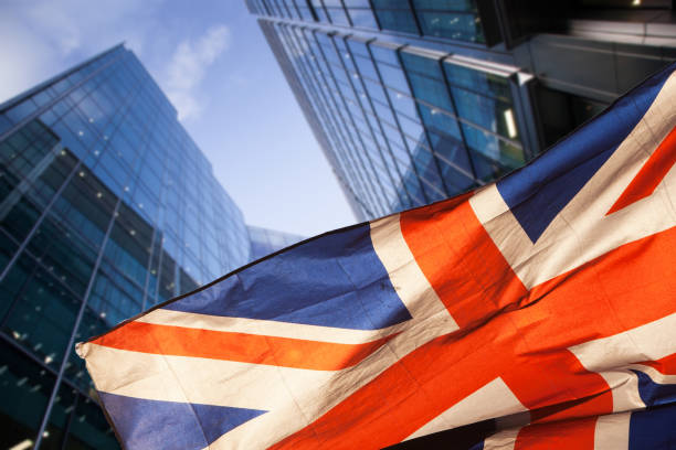 brexit concept - UK economy after Brexit deal - double exposure of flag and Canary Wharf business center skyscrapers stock photo