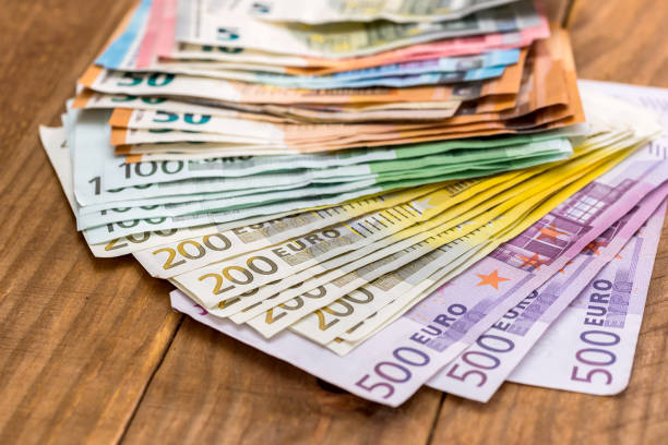 istock Stack of euro banknotes on wooden background 1080717954