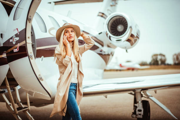 istock Young rich blonde female exiting a private airplane parked on a runway 1080719134