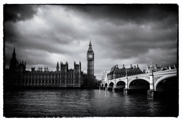 Looking across the Thames towards Big Ben and the Palace of Westminster. Dramatic black and white/film noir style.