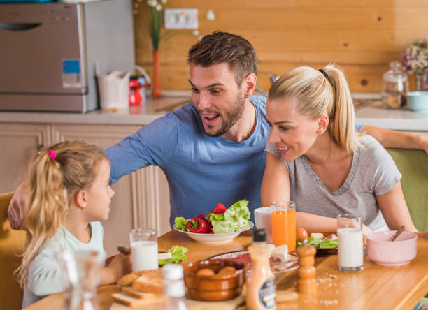 istock Happy parents and their daughter talking during breakfast time at dining table. 1080738360