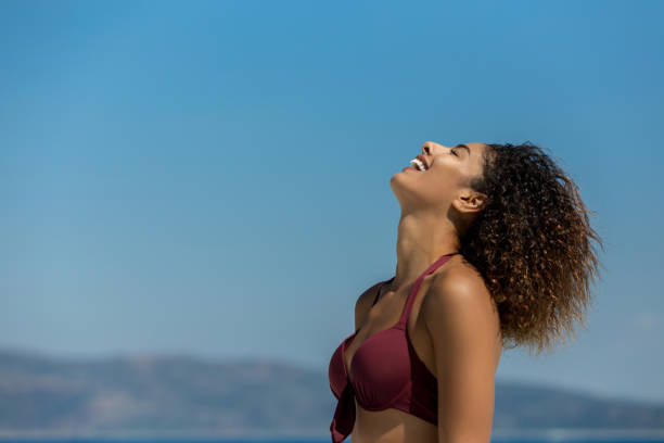 istock Beautiful young woman laughing on the beach 1080746366