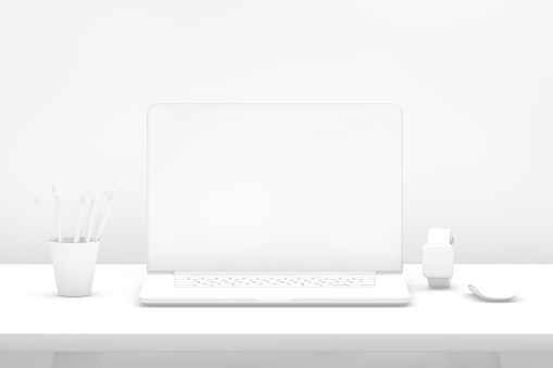 Home office desk with modern computer, coffee cup and houseplant.