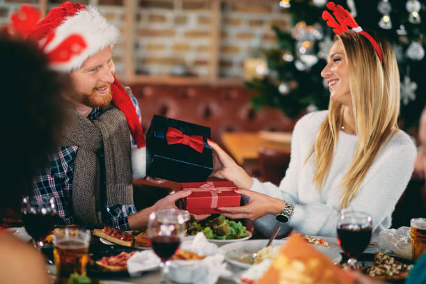 istock Friends giving gifts to each other while sitting at table. 1080763214