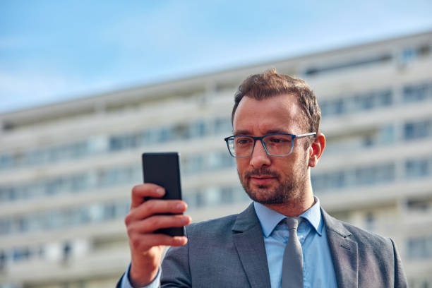 istock Businessman using his smartphone on the street. 1080764448