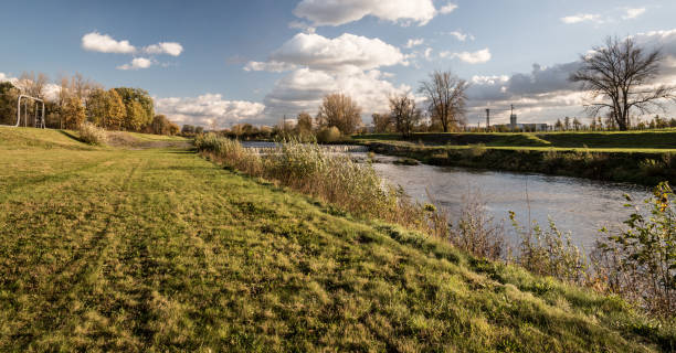 istock beautiful autumn scenery with river, colorful trees, grass and blue sky with clouds 1080781516